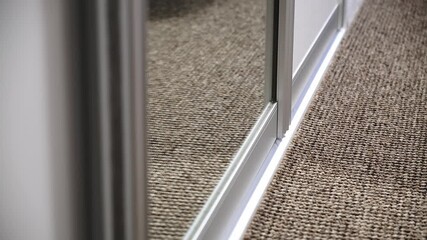 A system of sliding doors in the wardrobe, the system of opening and closing sliding doors of the compartment. Storage space for clothes. Rail for door wheels. Mirrored doors. High quality 4k footage.