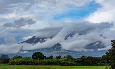 Mountains covered by clouds see from the plain, after the rain.