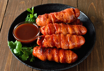 Bacon wrapped sausages with barbecue sauce