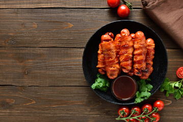 Bacon wrapped sausages with barbecue sauce
