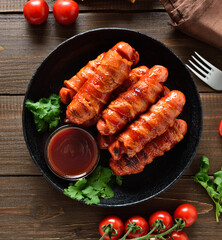 Bacon wrapped sausages with barbecue sauce