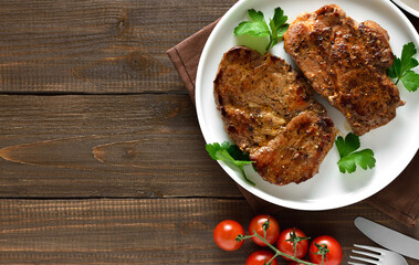 Juicy grilled pork steaks on plate