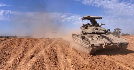 Fototapeta premium Aerial IDF Merkava Tanks Advancing Gaza Border showing IDF Merkava tanks advancing near the Gaza border in 2024. 
