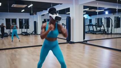 Woman boxing in gym wearing virtual reality headset fitness training - Powered by Adobe