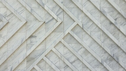 The wall is decorated with white granite slabs with a diagonal pattern, creating a smooth and luxurious surface. The image shows the texture and background of the white stone wall in a modern style.