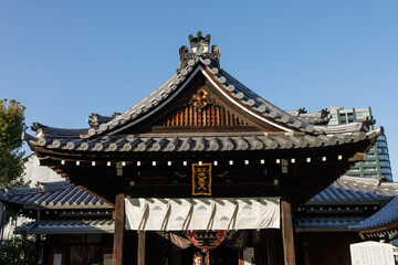 Fototapeta premium Osaka. Traditional Japanese Temple Gate With Ornately Curved Shingle Roof In Urban Style