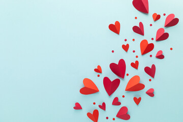 Saint Valentine Day red hearts decoration on blue background top view. Festive frame for love greeting and amour holiday.