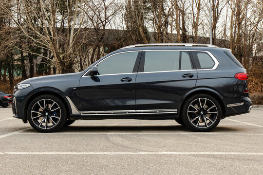 March 7, 2022, Seoul, South Korea - A side profile view of a dark gray BMW X7 40d luxury SUV parked in an outdoor lot.
