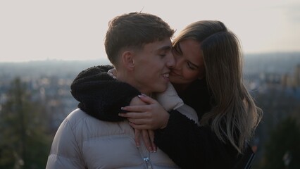 A young couple embraces affectionately with the Paris cityscape in the background showcasing love and connection. This image is suitable for travel tourism and relationship themes in France. © 4kclips