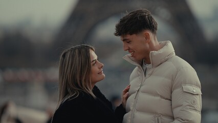A romantic couple is standing in Paris France with the Eiffel Tower in the background The young...