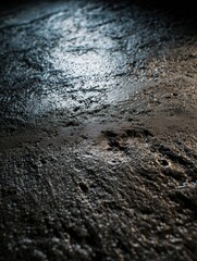 Close-up of wet textured surface reflecting light creating an abstract and dramatic ambiance