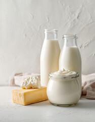 Assortment of dairy products on a table. Milk, yogurts, hard and soft cheeses in a light minimalist composition. Healthy nutrition and fresh food concept.