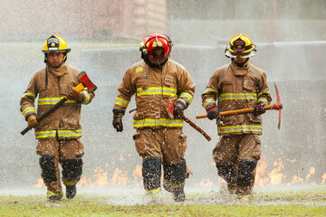Firefighter team carrying tools during emergency training exercise