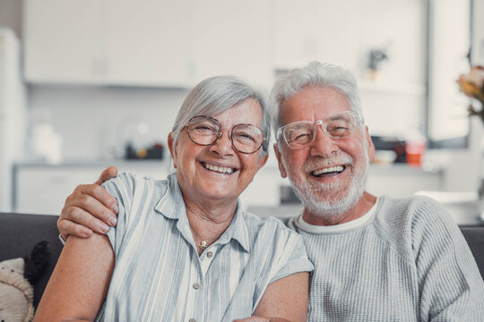 Home, relax and old couple on couch, funny and happiness with love, romance and conversation. Apartment, senior man and mature woman with smile, marriage and relationship with joke in living room