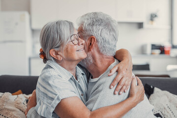 Hug, love and safe with a senior couple hugging or embracing in the kitchen of their home together. Happy, smile and affection with an elderly male and female pensioner sharing a warm embrace