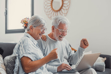 Excited senior couple, laptop and cheering in home for online shopping deal, sales and good news in lottery. Happy old man, woman and wow celebration on computer for winning, surprise and competition