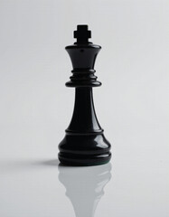 Photographic style shot of a smooth, polished onyx black chess piece (king) with subtle reflections, placed on a white reflective surface.