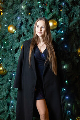 Happy young woman against the backdrop of festive Christmas lights