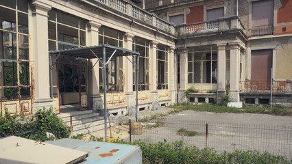 Abandoned hospital courtyard with classical architecture