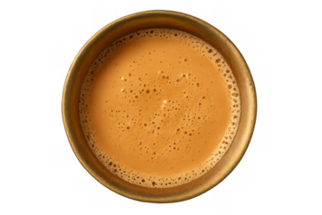 Masala chai tea overhead shot in a traditional brass cup, hot indian beverage with foam, isolated on transparent background