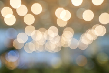 Warm bokeh light pattern with soft yellow and white circular blurs for festive and tranquil...