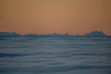 Berggipfel erscheinen über der Wolkendecke bei Sonnenaufgang in den Ostalpen