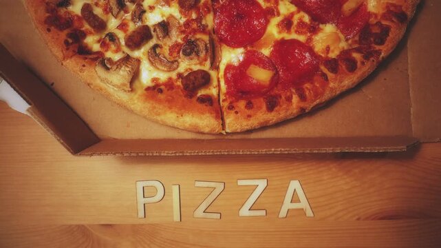 Pizza spelled out in animated stop motion wood letters and a pepperoni, pineapple, sausage and mushroom pizza.