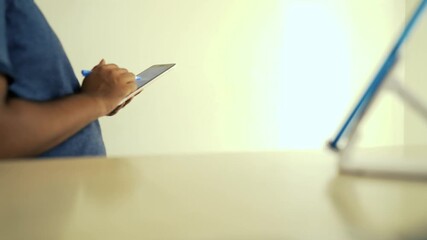 Person Using Tablet with Stylus on Desk