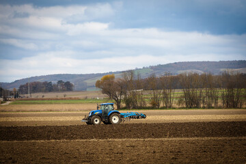 Tractor plowing a hilly rural field