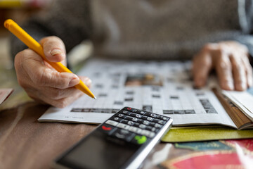 Solving a crossword puzzle with a mobile phone nearby