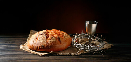 Bread and silver cup with wine. Lord's Supper. Communion in church. Symbol of the body and blood of Jesus. Redemption forgiveness of sins.