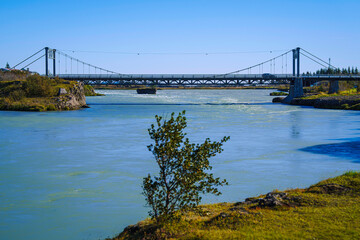 Fototapeta premium Ölfusárbrú suspension bridge, 84 meters long, first built in 1891 and rebuilt in 1945, spanning the River Ölfusá along Route 1 in the charming historic town of Selfoss, Iceland