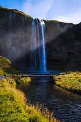 Seljalandsfoss Waterfall, volcanic glacier fed falls cascading from a 197 foot cliff in the South Region of Iceland right by Route 1