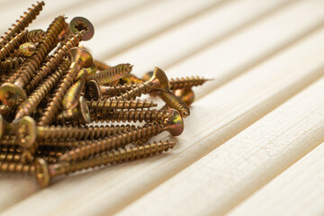 Yellow metal screws on a wooden table