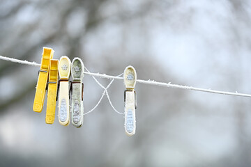Givre sur des pinces &agrave; linge en plastique, laiss&eacute;s sur une corde &agrave; linge en hiver