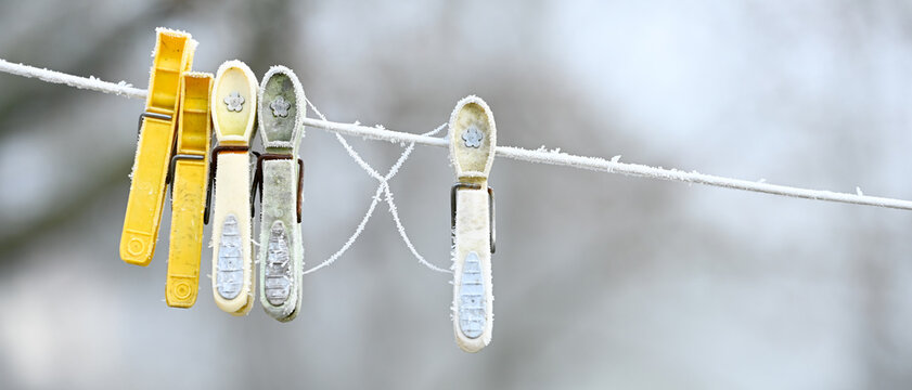 Givre sur des pinces &agrave; linge en plastique, laiss&eacute;s sur une corde &agrave; linge en hiver, format banni&egrave;re