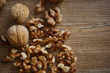 Walnuts and shelled nuts on a wooden surface arranged around each other in a simple setting