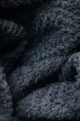 The texture of a soft black fleece fabric with visible fibers and folds