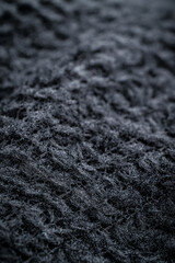The fabric of black fleece, a synthetic knit with a soft, fluffy texture