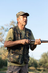 The hunter reloads his gun and prepares to shoot at game