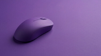 Wireless computer mouse on purple background with copy space