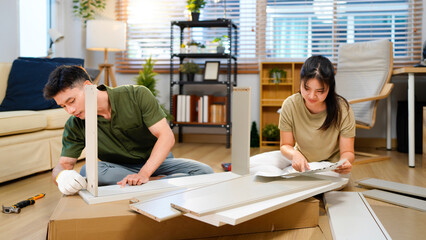 couple assembling wooden furniture together, Young asian couple assembly a new furniture at home