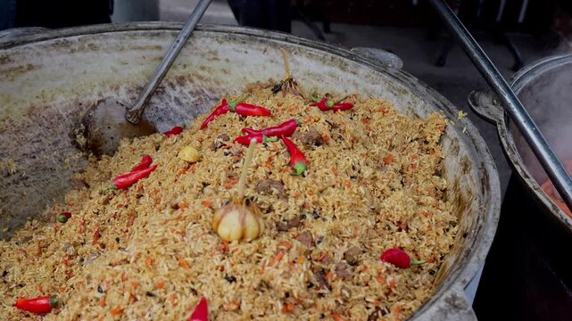 Vibrant festival scene with flavorful rice dish, Bustling market environment featuring massive traditionally cast rice dish infused with garlic and fiery chilies
