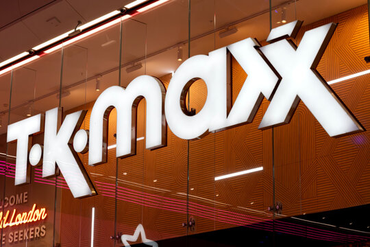 London, UK - December 18 2025: Illustrative editorial TK Maxx logo illuminated on retail store entrance signage behind glass at night