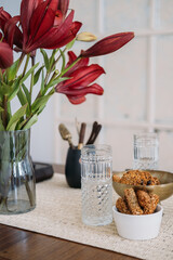 Morning snack. Tea time. Healthy oatmeal in bowl with tasty wholegrain snack rich in protein fiber calcium glass placed on flower free space.