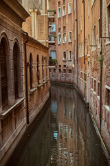 Tourist walking through narrow Venetian streets contemplating the scenic canals and traditional gondolas in Venice Italy