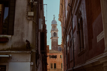 Tourist walking through narrow Venetian streets contemplating the scenic canals and traditional gondolas in Venice Italy