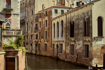 Tourist walking through narrow Venetian streets contemplating the scenic canals and traditional gondolas in Venice Italy