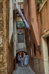 Tourist walking through narrow Venetian streets contemplating the scenic canals and traditional gondolas in Venice Italy