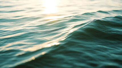 Ocean waves gently rolling in the sunlight. The water surface reflects the sun's glow, creating a serene and calming seascape with hues of blue, green, and gold. Perfect for relaxation.